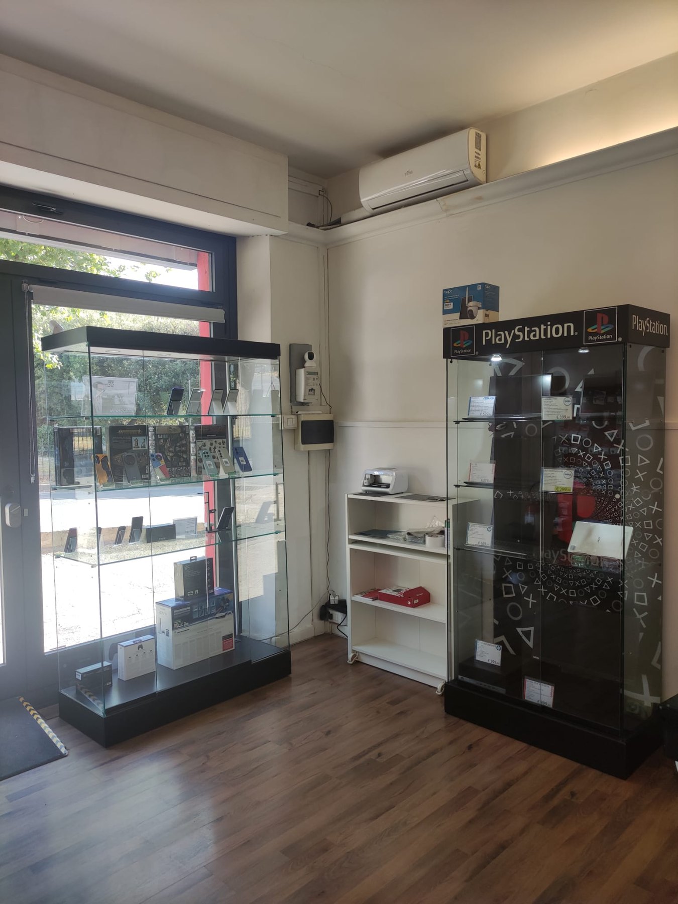 Vetrine con computer portatili e console in vendita nel negozio di Amelia